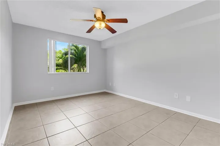 Empty room featuring ceiling fan and light tile patterned flooring