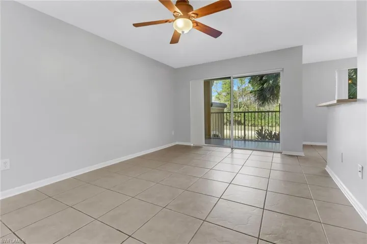 Empty room featuring ceiling fan and light tile patterned floors