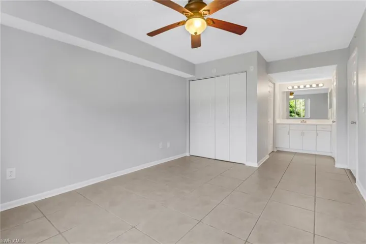 Unfurnished bedroom featuring ceiling fan, a closet, light tile patterned floors, and sink