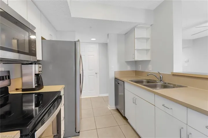 Kitchen with appliances with stainless steel finishes, a textured ceiling, ceiling fan, sink, and white cabinets
