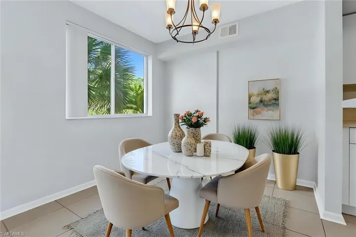 Tiled dining space featuring an inviting chandelier