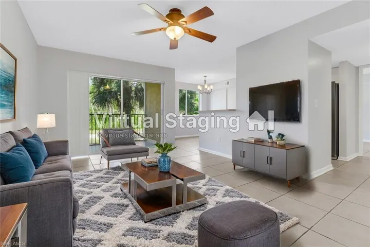 Tiled living room with ceiling fan with notable chandelier