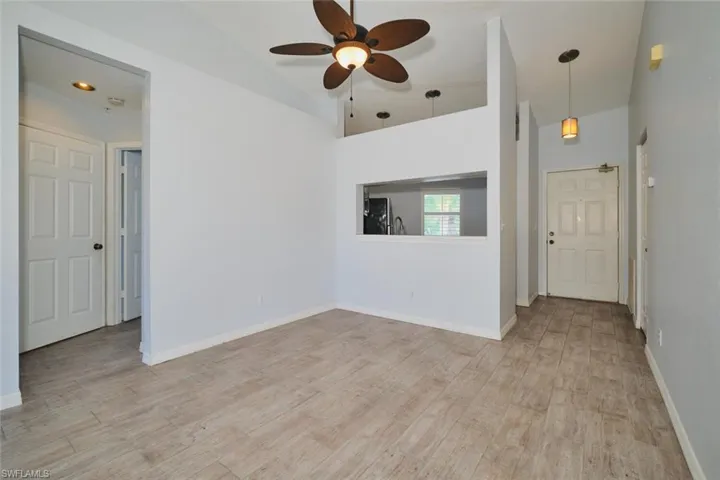 Dining room featuring a lighted ceiling fan, lofted ceiling, and tile floors