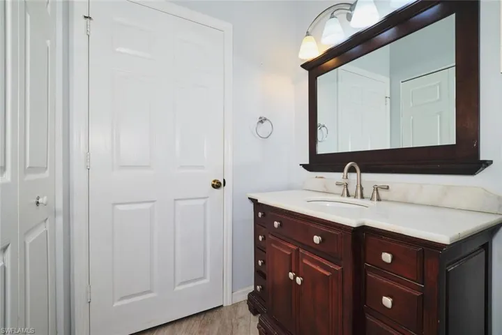 Full bath with wood vanity, walk-in closet.