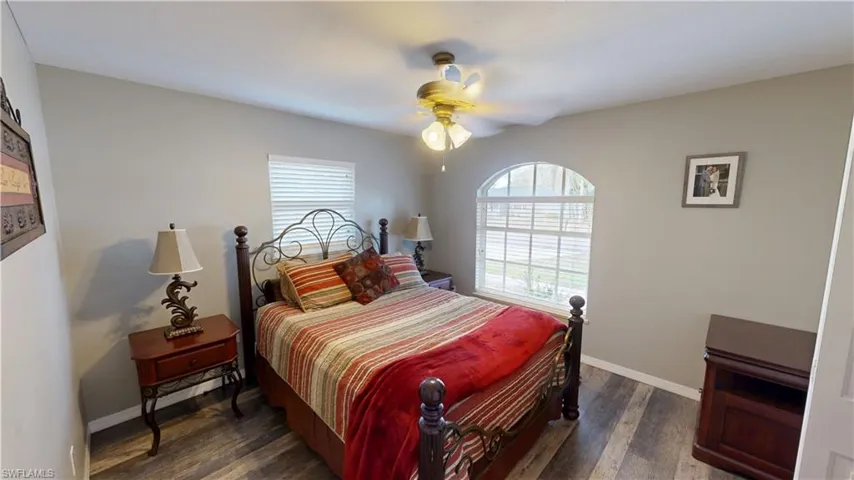 Bedroom with dark hardwood / wood-style flooring and ceiling fan