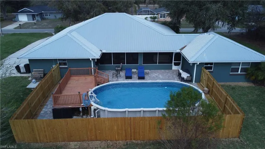 View of swimming pool with a sunroom and a deck