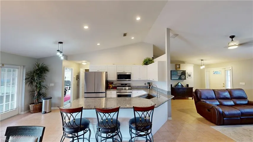 Kitchen featuring white cabinetry, sink, stainless steel appliances, and hanging light fixtures