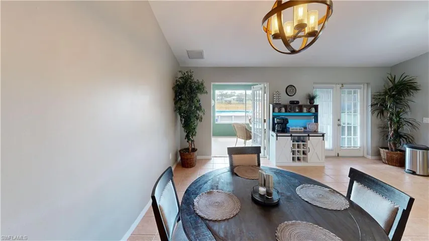 Tiled dining area featuring a notable chandelier