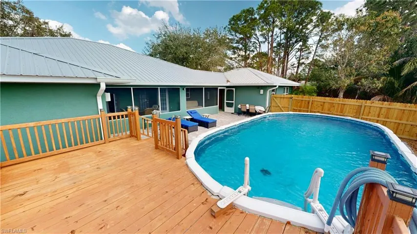 View of swimming pool with a sunroom, outdoor lounge area, and a deck