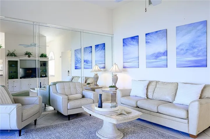 Living area with a ceiling fan and tile patterned flooring