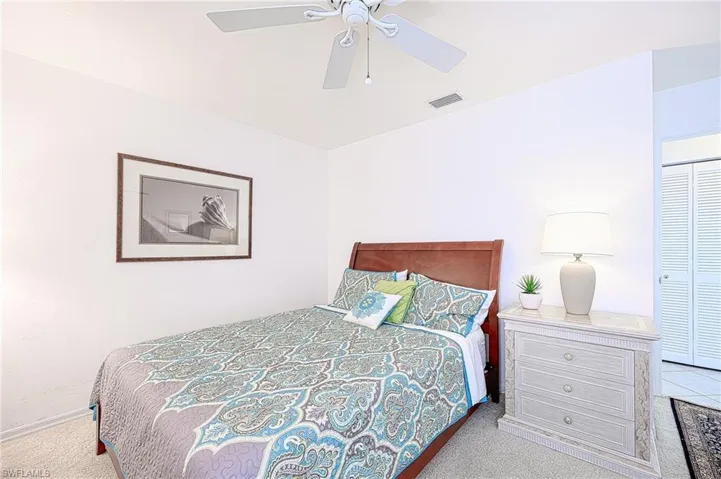 Carpeted bedroom featuring ceiling fan and a closet