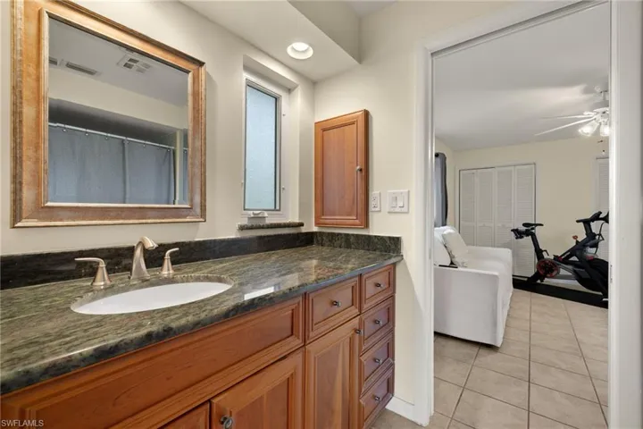Bathroom with ceiling fan, tile patterned flooring, and vanity