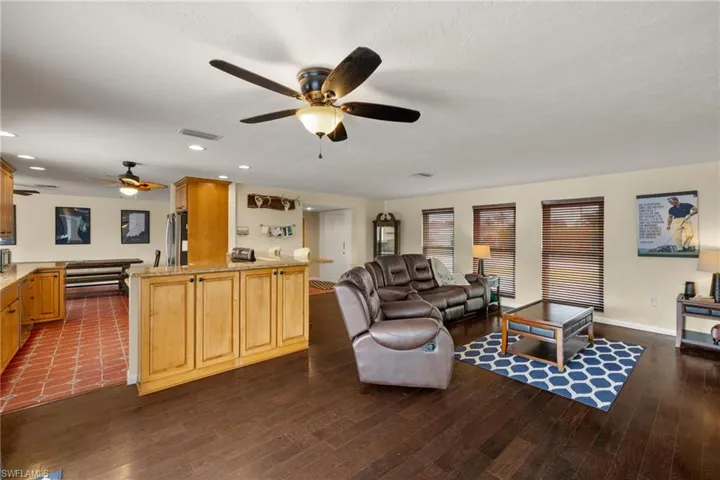 Living room featuring ceiling fan, dark hardwood / wood-style flooring, and a textured ceiling
