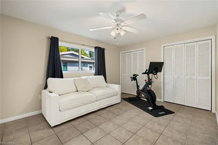 Workout room with light tile patterned floors and ceiling fan