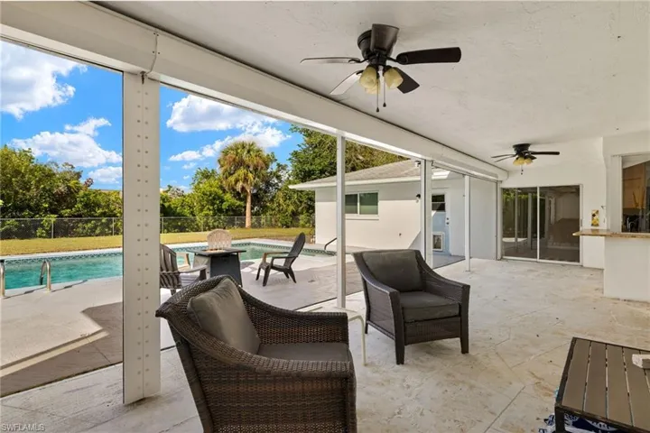 View of patio featuring ceiling fan and a fenced in pool