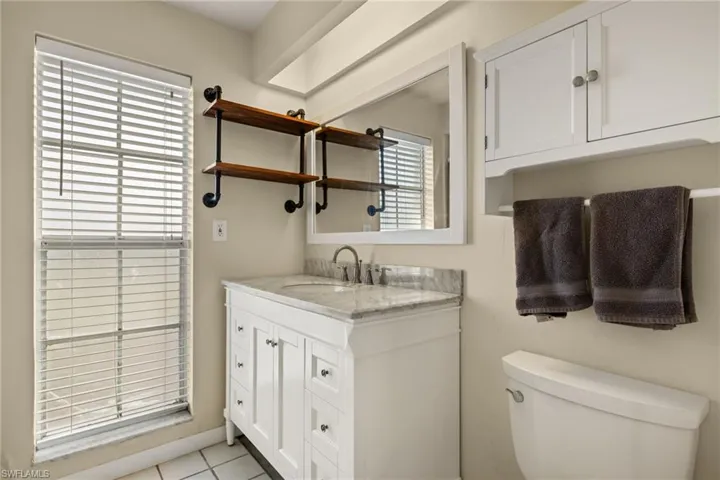 Bathroom featuring tile patterned flooring, vanity, and toilet
