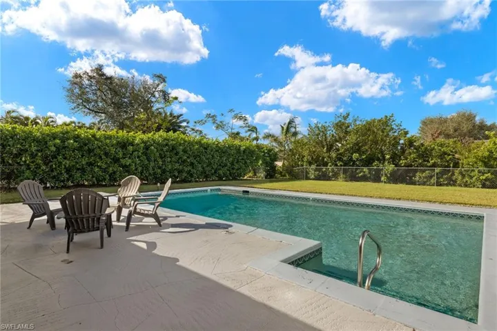 View of swimming pool with a patio area and a yard