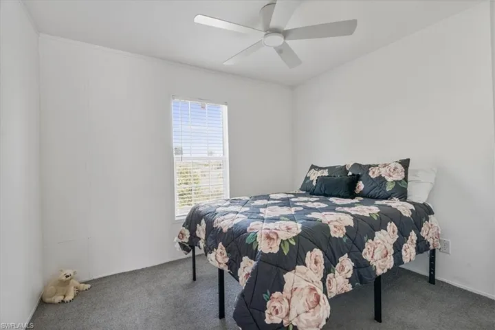 Carpeted bedroom featuring crown molding and ceiling fan