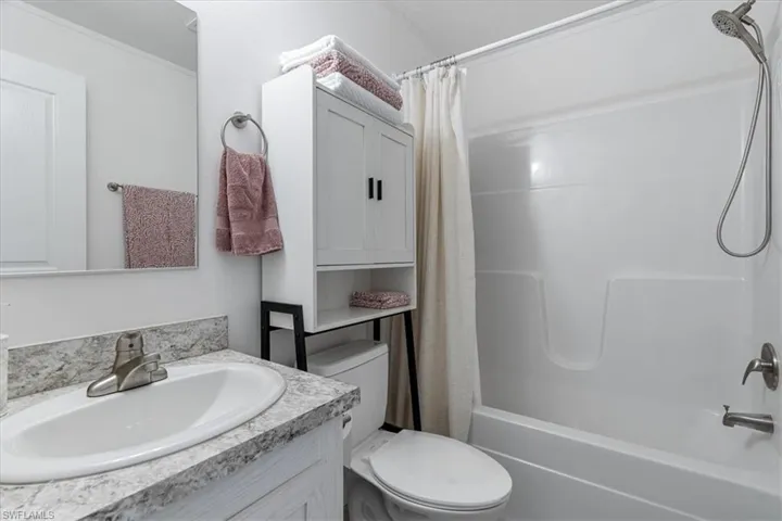 Full bathroom with vanity, toilet, and shower / bath combo with shower curtain