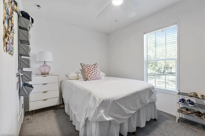 Bedroom featuring ceiling fan and dark carpet