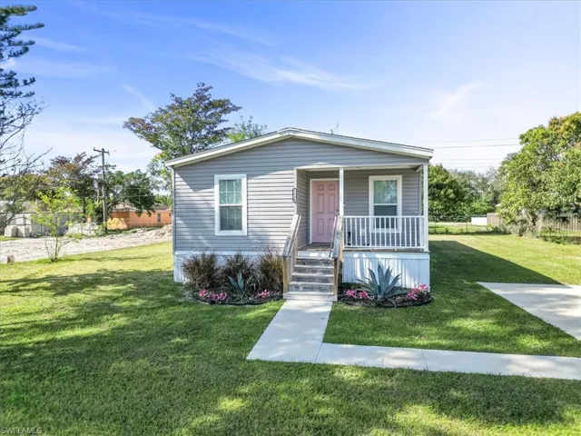 View of front facade featuring covered porch and a front lawn