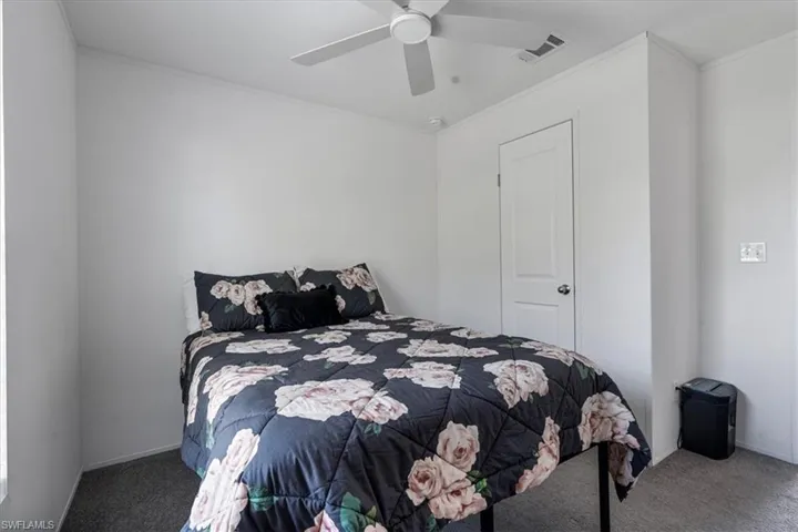 Carpeted bedroom featuring crown molding and ceiling fan