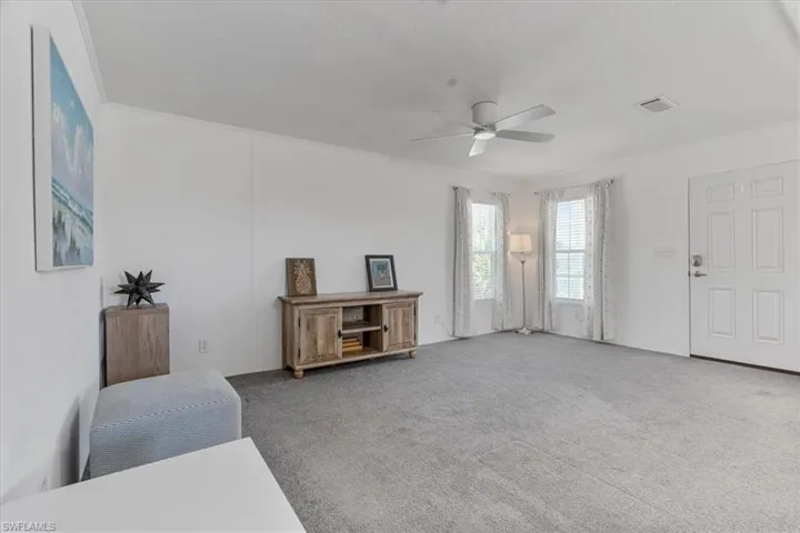 Sitting room featuring ceiling fan and carpet flooring