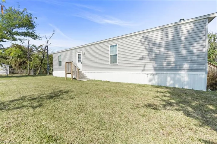 Back of property with a lawn