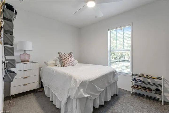 Bedroom featuring multiple windows, carpet, and ceiling fan