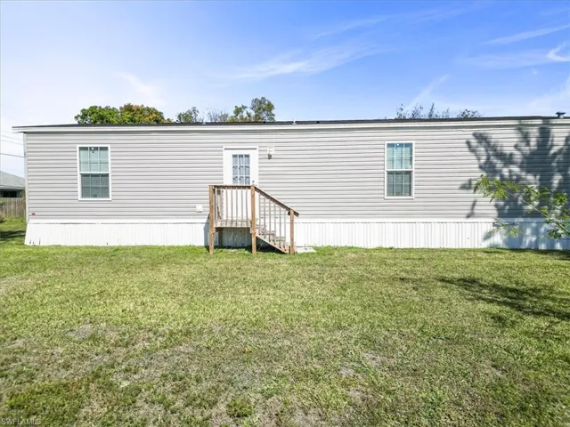 Back of property with a lawn