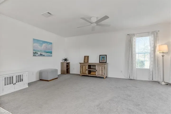 Miscellaneous room with ceiling fan, ornamental molding, and carpet flooring
