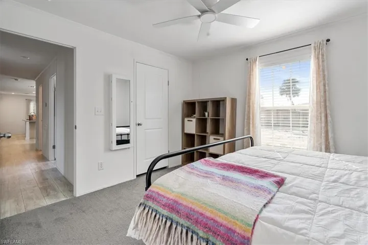 Bedroom featuring light carpet, crown molding, and ceiling fan