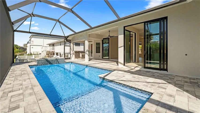 Combined pool / hot tub featuring a patio, a sunroom, and glass enclosure