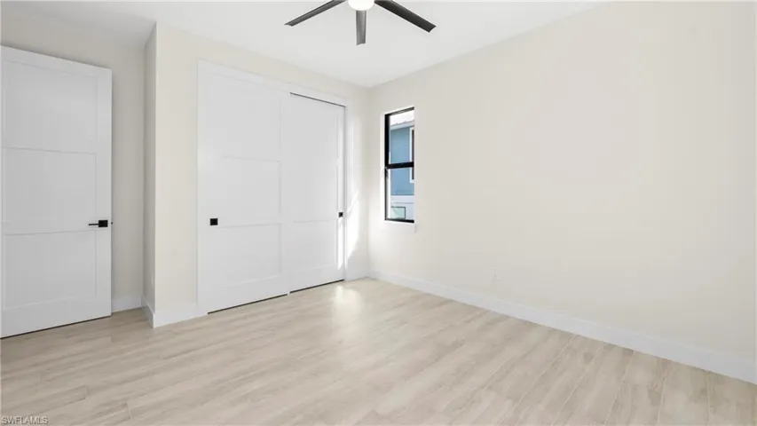 Unfurnished bedroom featuring light wood finished floors, a ceiling fan, and a closet
