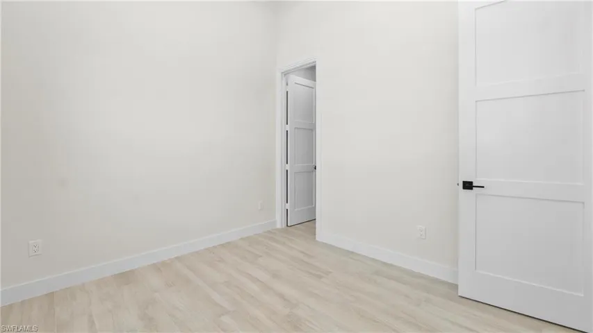 Unfurnished bedroom with baseboards and light wood-type flooring