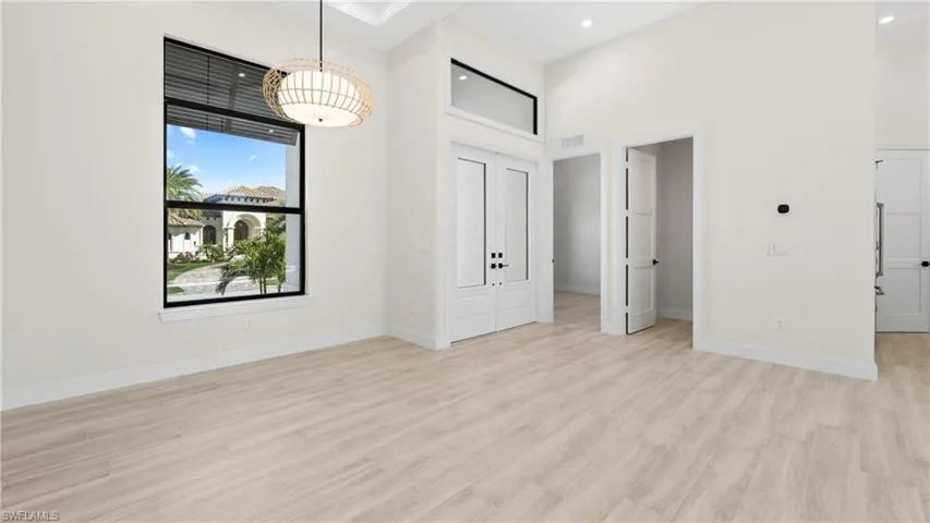 Unfurnished dining area featuring a high ceiling, light wood-style flooring, and recessed lighting