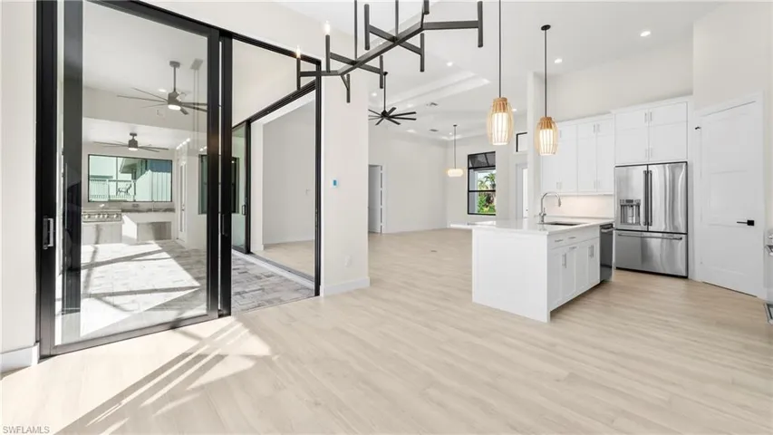 Kitchen featuring open floor plan, white cabinets, and stainless steel appliances