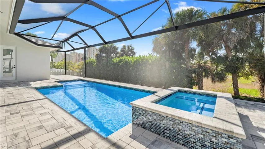 Relaxing pool / spa featuring a patio, a sunroom, and a lanai