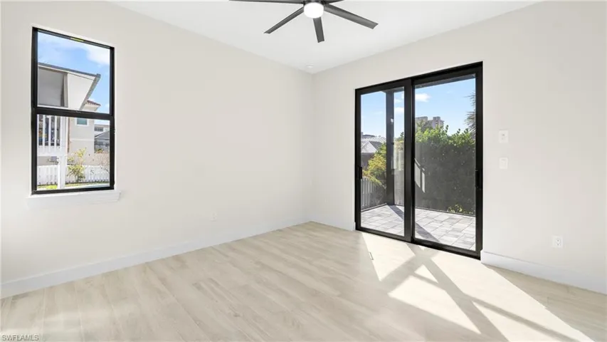 Spare room with light wood-style flooring, ceiling fan, and plenty of natural light