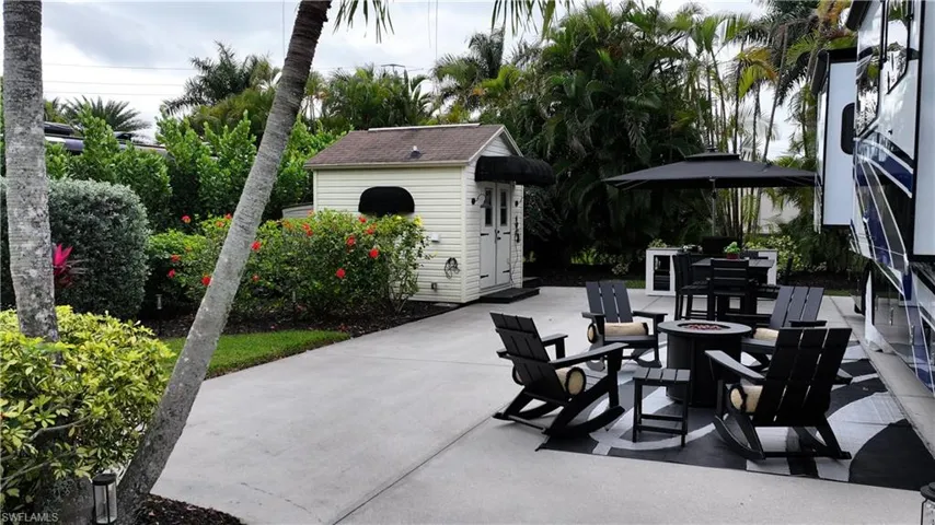 View of patio with an outdoor structure, a fire pit, and outdoor dining space