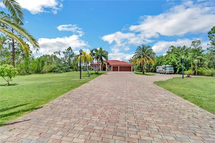View of front of property featuring a garage and a front lawn