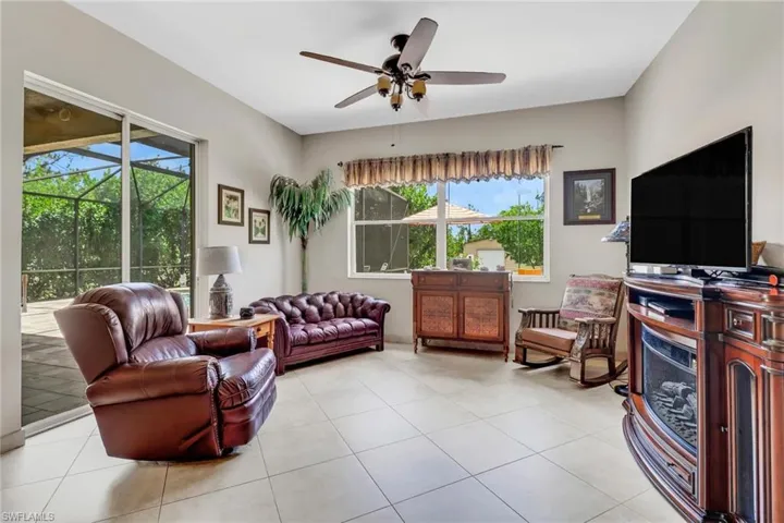 Tiled living room featuring a wealth of natural light and ceiling fan