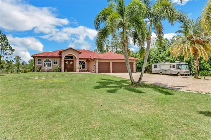 View of front of property with a garage and a front yard