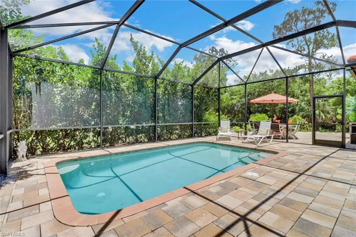 View of swimming pool with a patio and screened enclosure