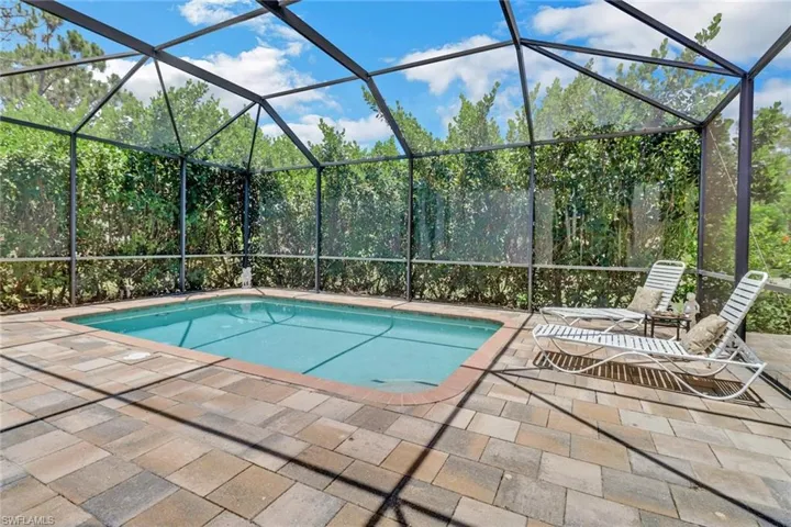 View of swimming pool featuring a patio and private, screened enclosure