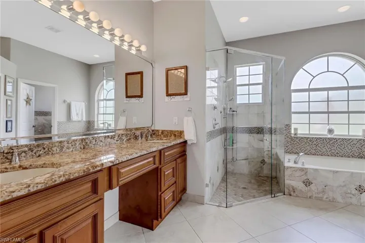 Bathroom featuring double vanity, and shower with separate bathtub