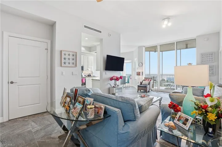 Living room featuring expansive windows and tile flooring - Virtually Edited Image