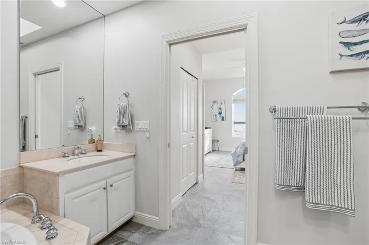 Ensuite bathroom with vanity, a bath, and a closet - Virtually Edited Image