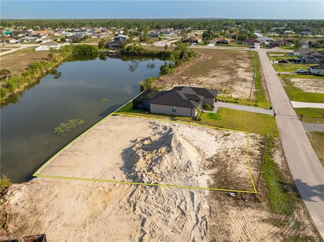 Aerial perspective of suburban area featuring property boundaries highlighted and a large body of water