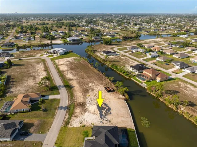 Aerial view of property's location with nearby suburban area and a nearby body of water